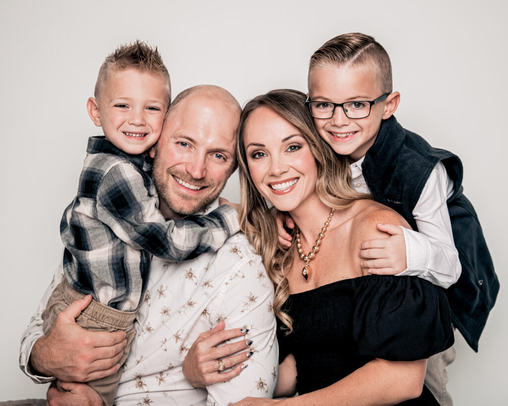 Happy family of four posing together and smiling.