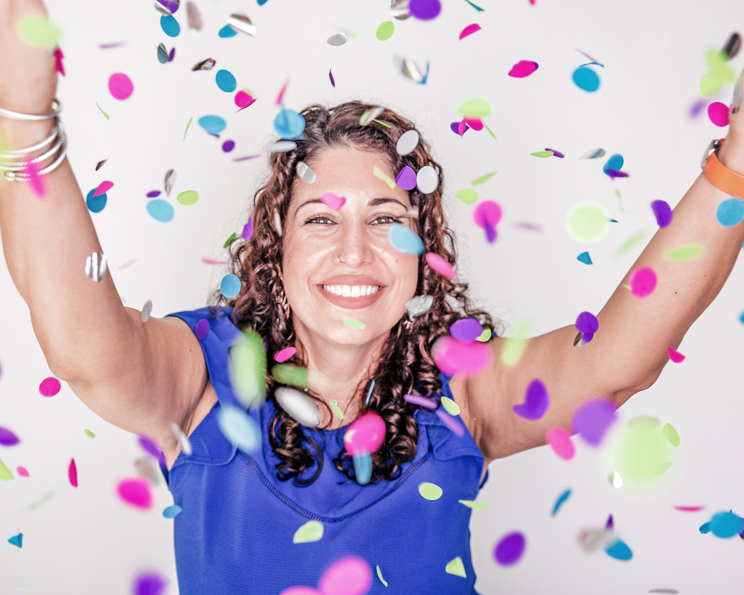 Joyful woman celebrating with colorful confetti.